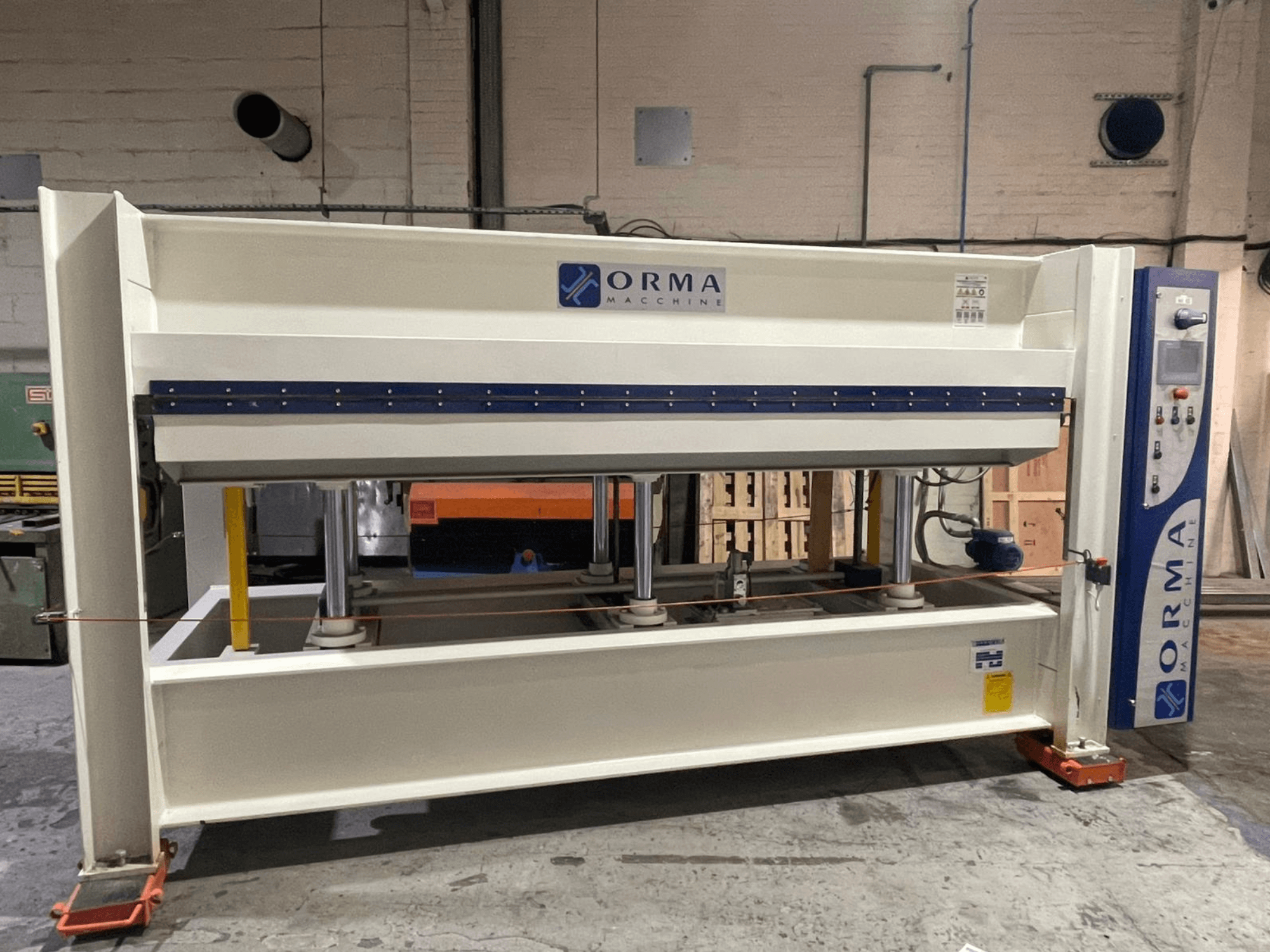Presse hydraulique Orma Macchine vue de face, avec quatre supports verticaux et un panneau de commande sur le côté droit.