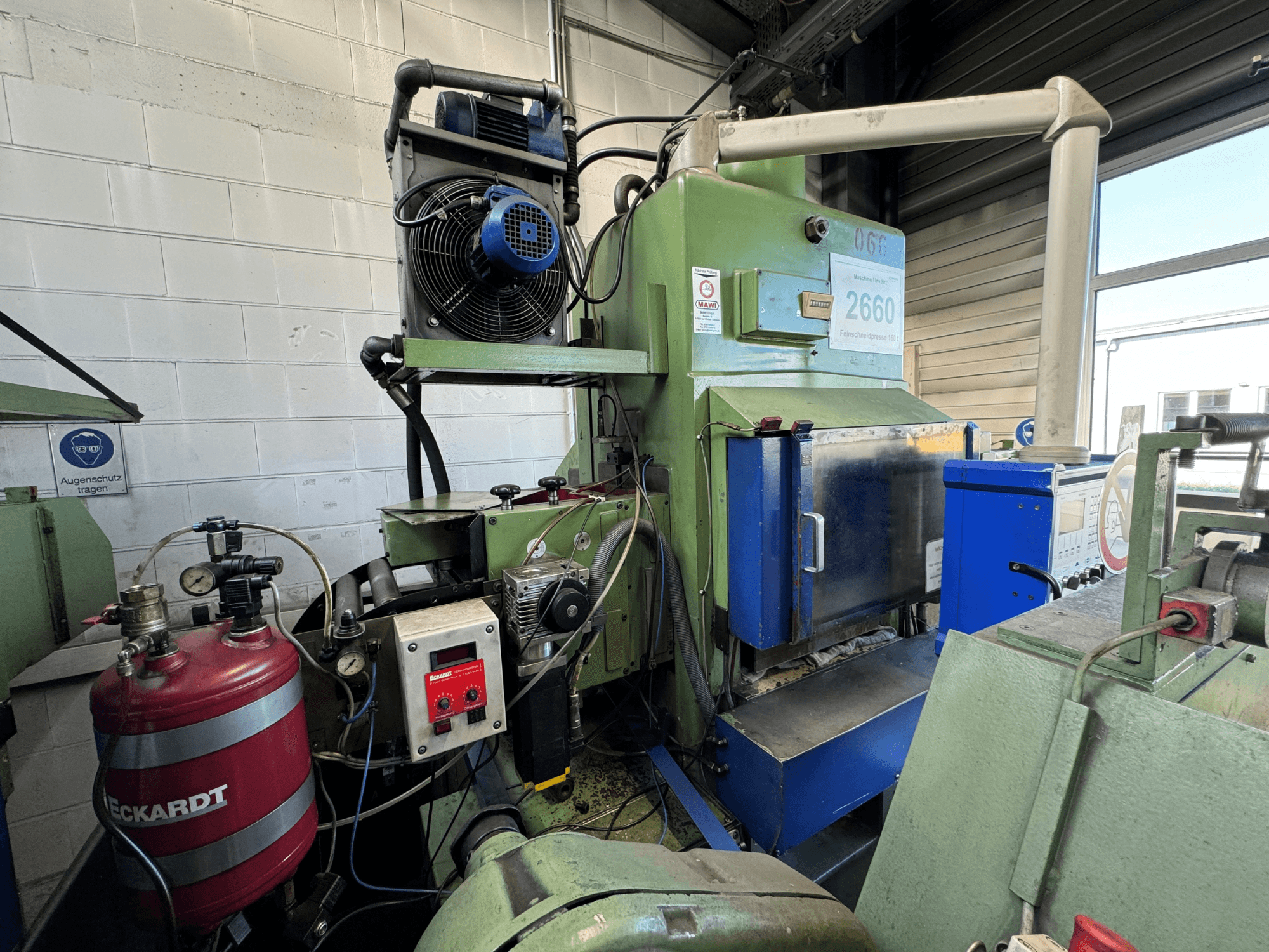 Machine industrielle verte avec panneau bleu, ventilateur monté, cadrans de contrôle et réservoir rouge étiqueté "ECKARDT", vue de face.